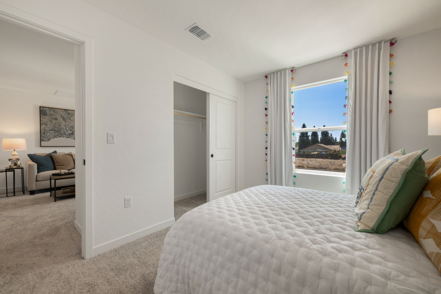 A bedroom with a large window.