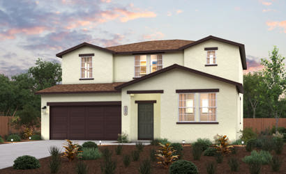 A house with a garage and bushes in front of it.