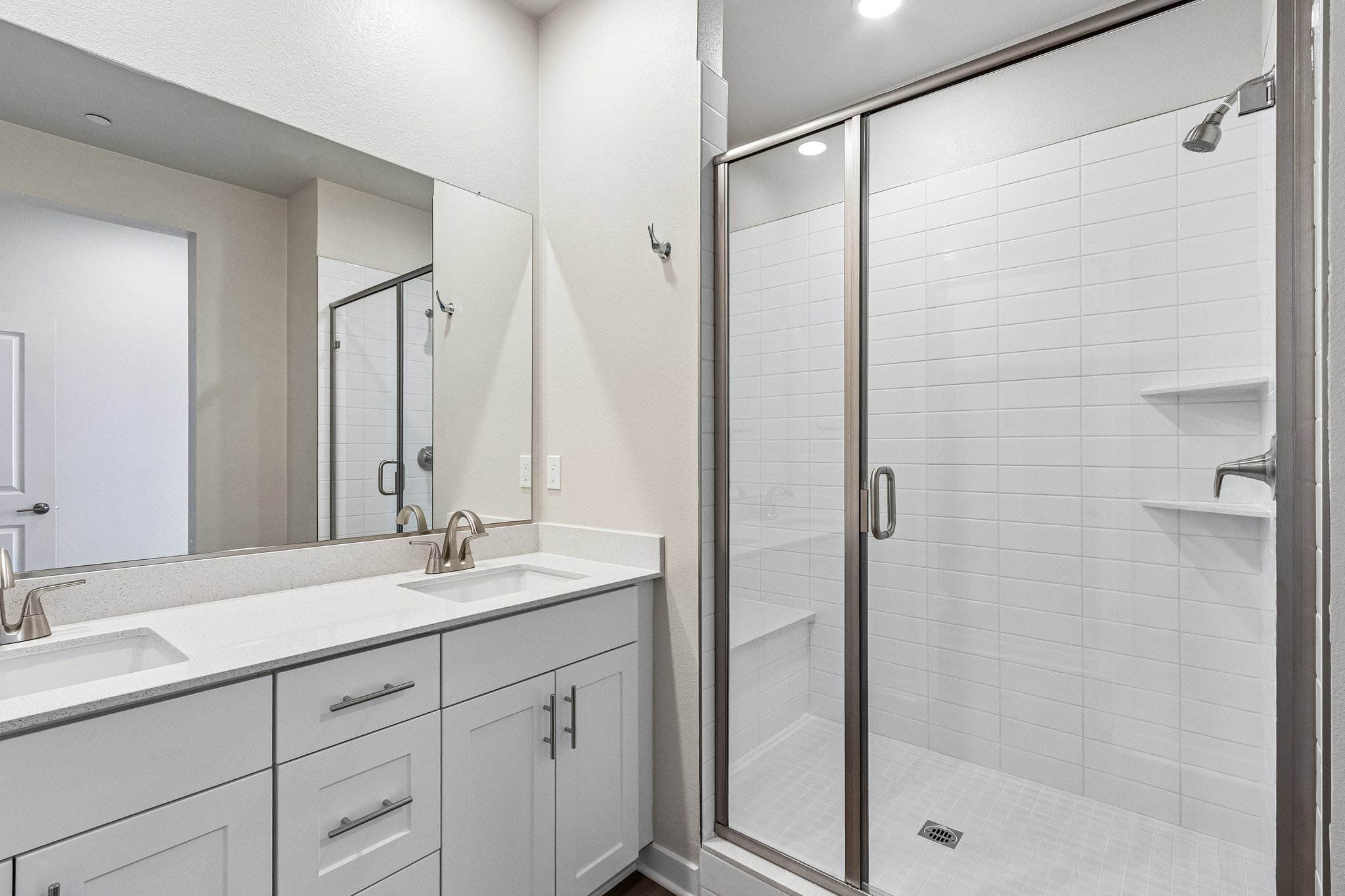 A bathroom with a shower unit and sinks.