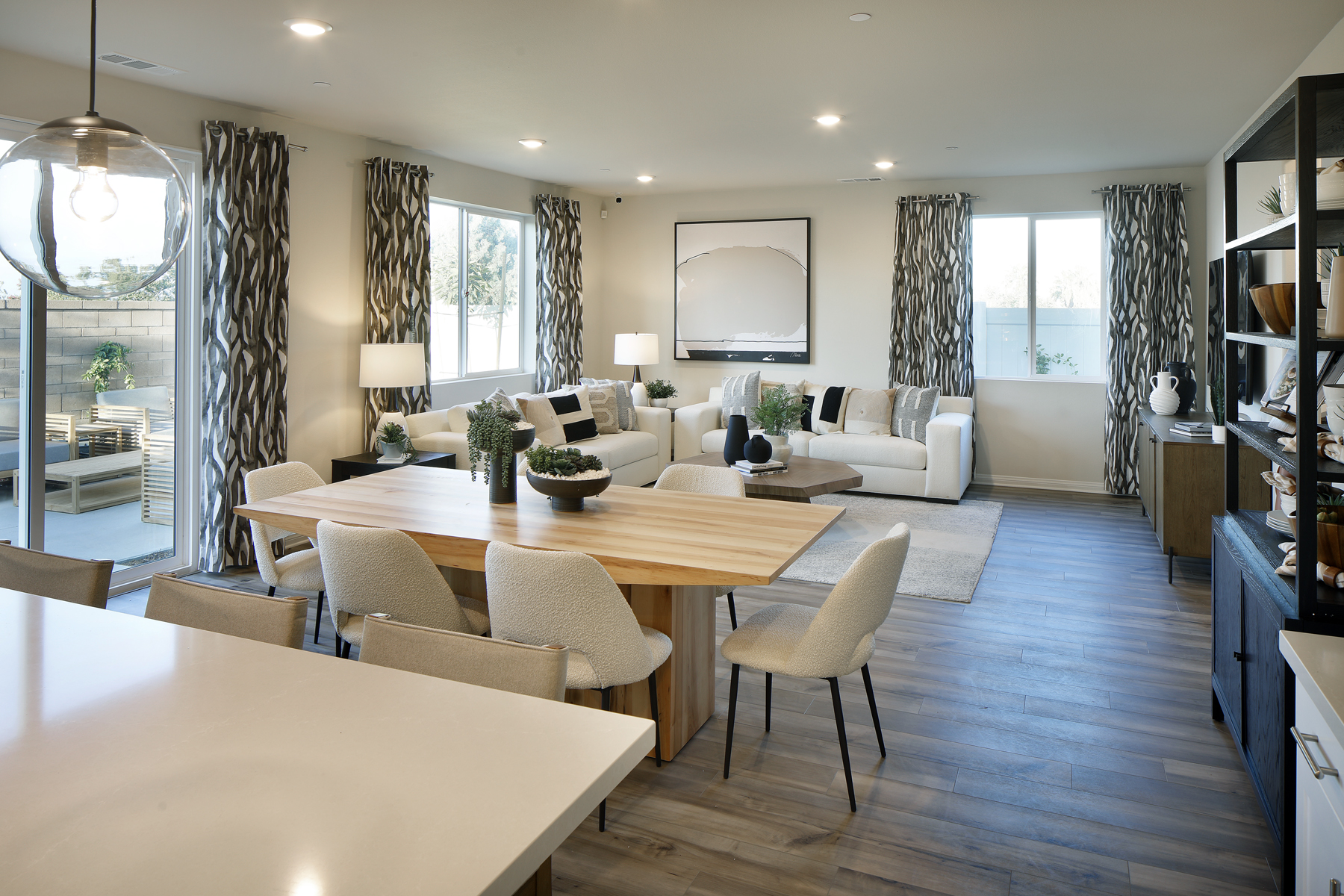 A large living room with a large dining table and a large window.