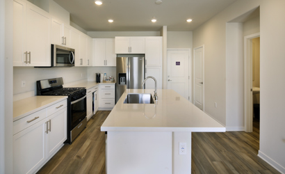 A kitchen with white cabinets.