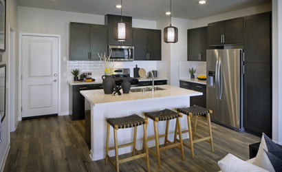 A kitchen with a bar and stools.