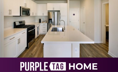 A kitchen with white cabinets.
