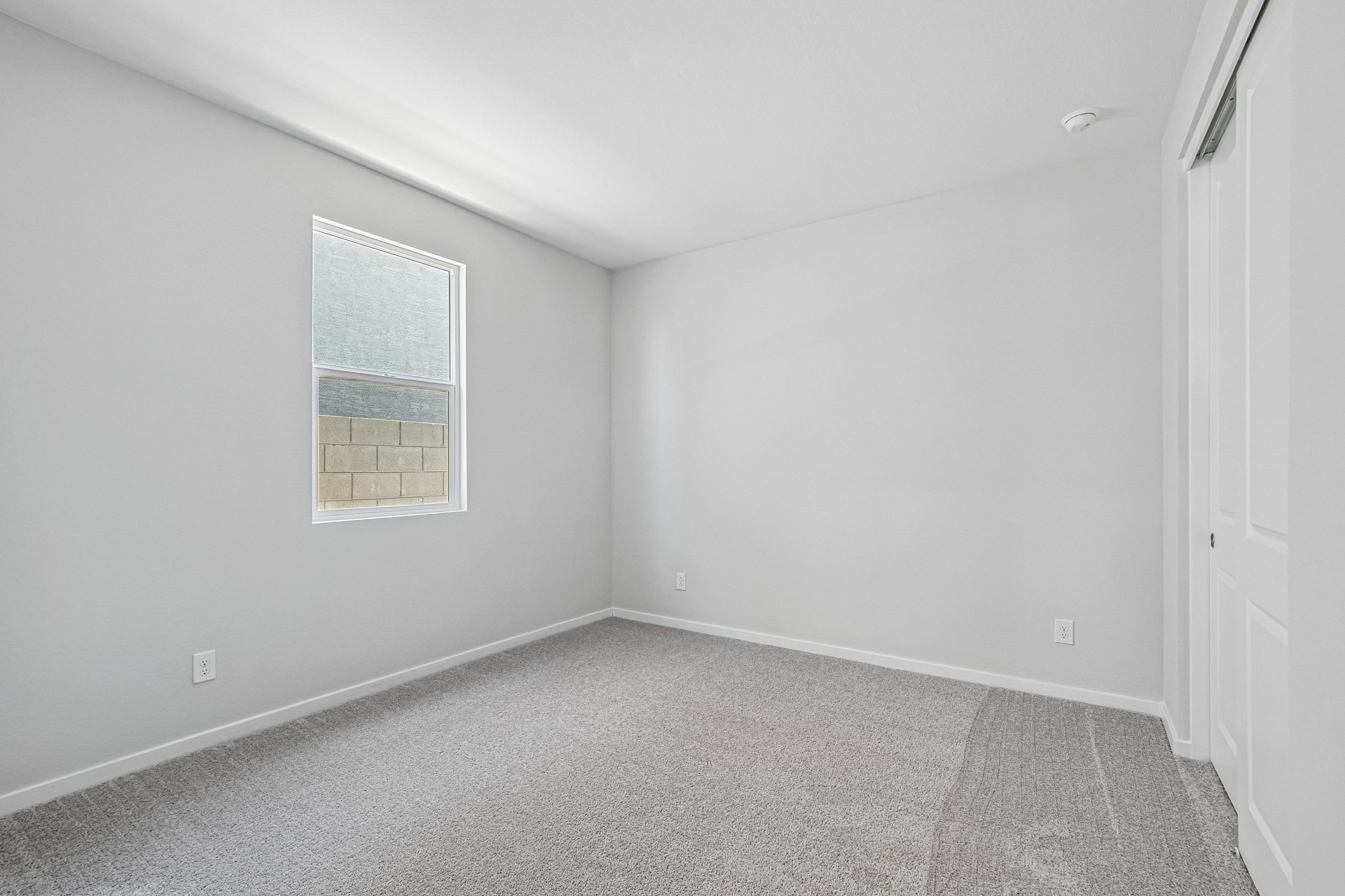 A room with a white wall and a window.