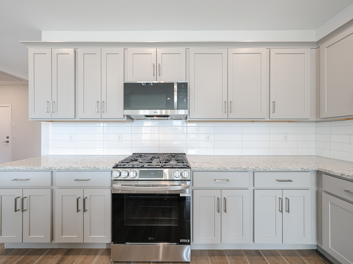 A kitchen with white cabinets.