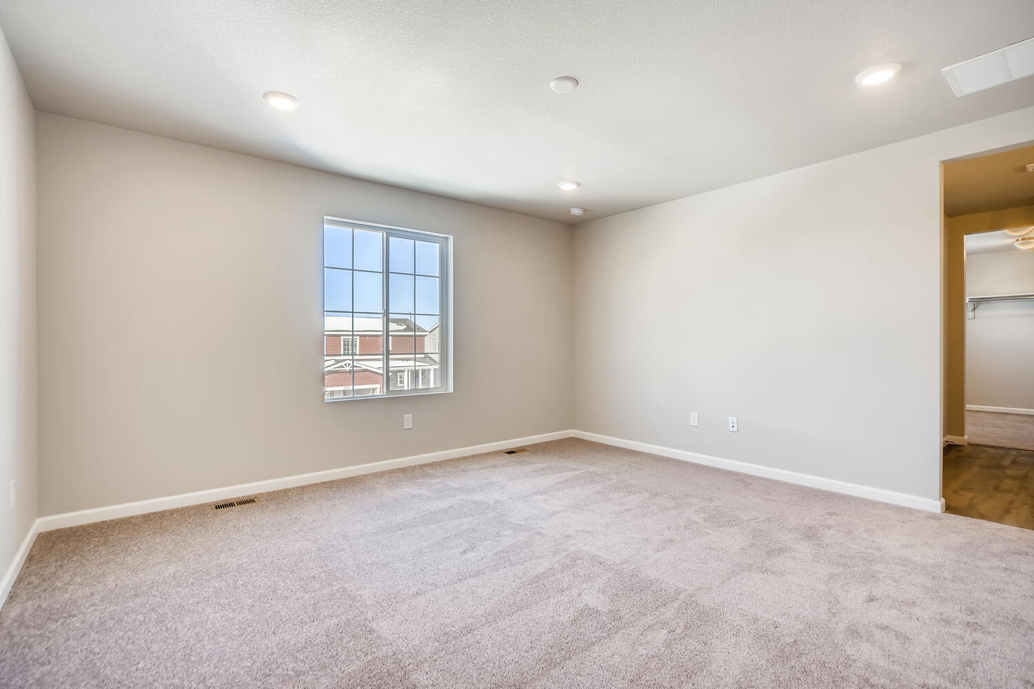 A room with a carpet and a window.