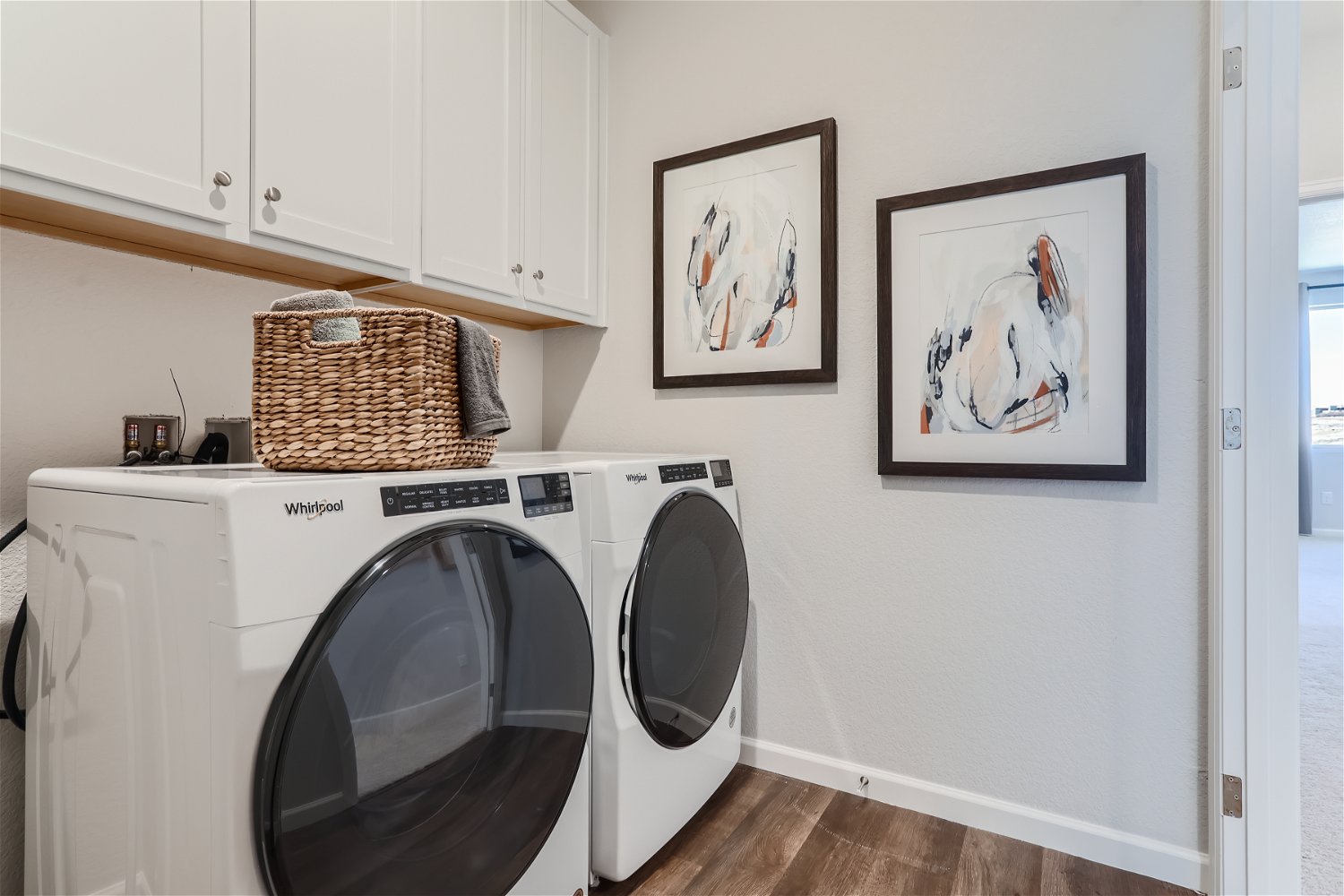 A laundry room with a basket and a dryer.