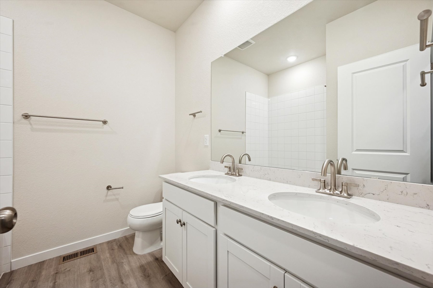 A bathroom with a sink toilet and mirror.