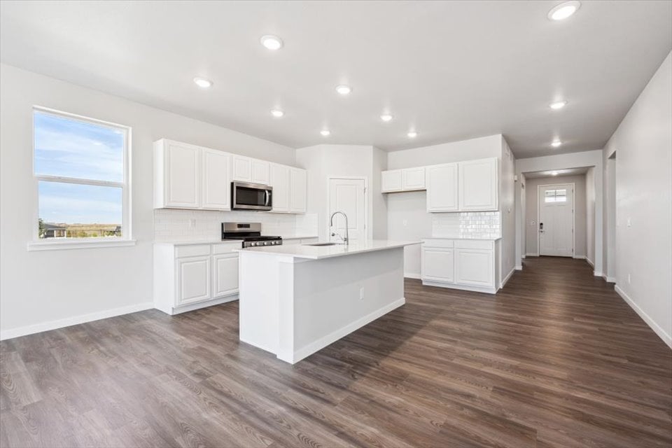 A kitchen with white cabinets.