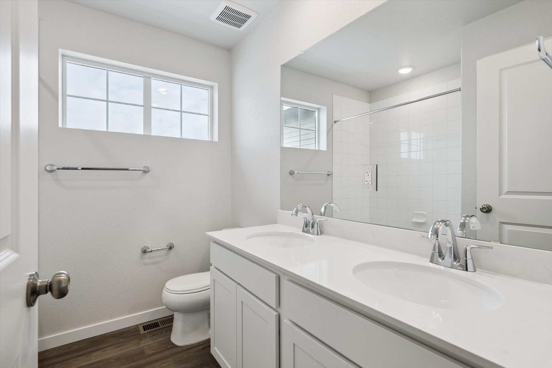 A bathroom with a large mirror.