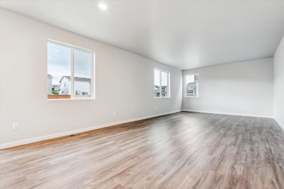 A room with a wood floor and windows.