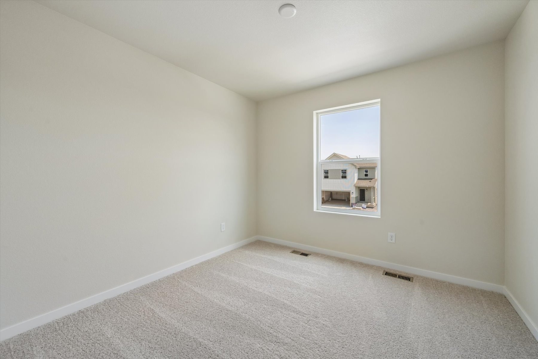 A room with a window and a carpet.