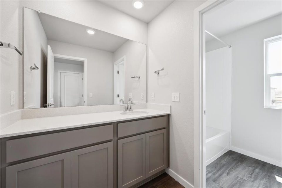 A bathroom with a sink and a shower unit.