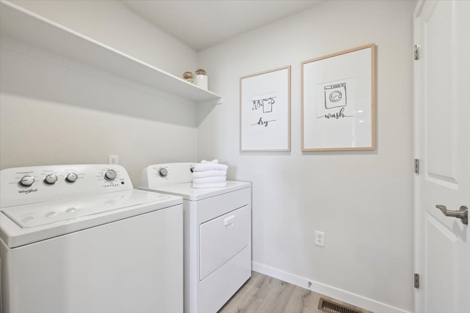 A white laundry room with a washer and dryer.