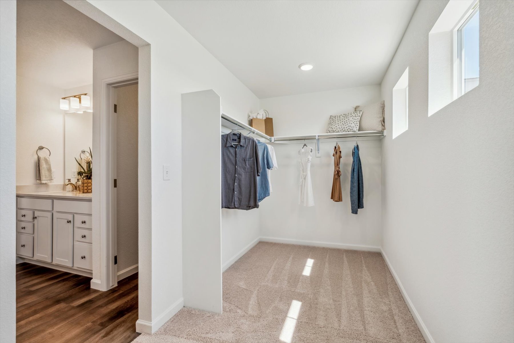 A room with white walls and a wood floor with a white door.
