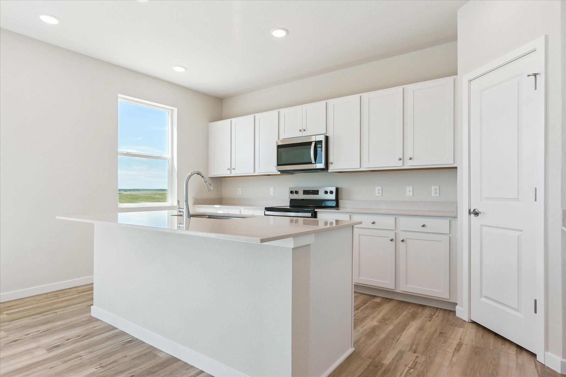 A kitchen with white cabinets.