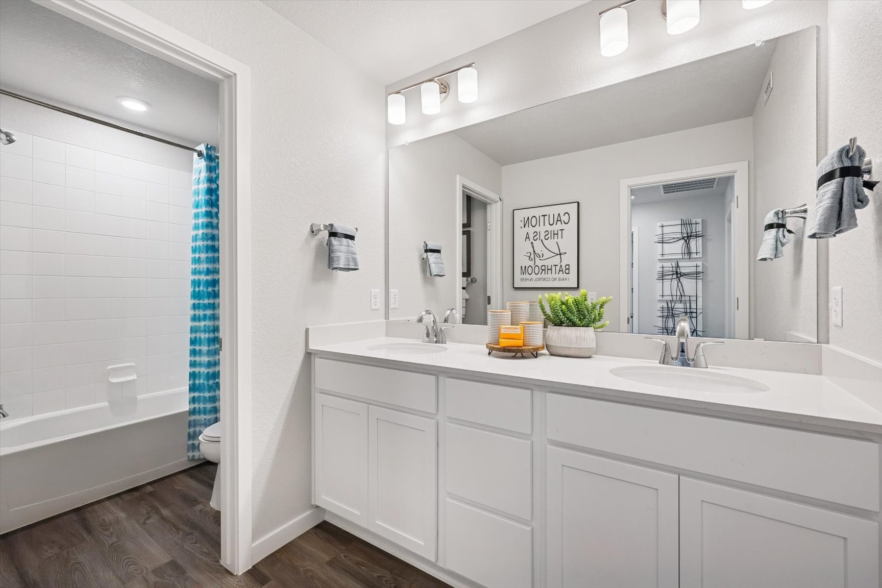 A bathroom with a tub sink and a mirror.