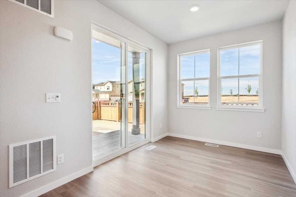 A room with a wood floor and windows.