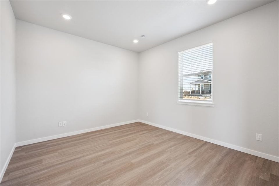 A room with a wood floor and a window.