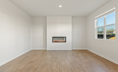 A room with a fireplace and a wood floor.