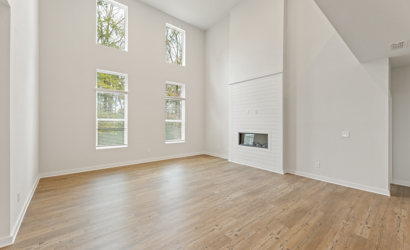 A room with a fireplace and a wood floor.