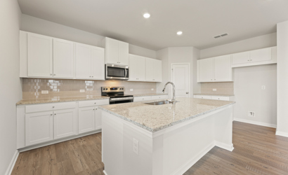 A kitchen with white cabinets.