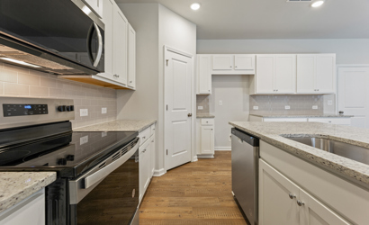 A kitchen with white cabinets.