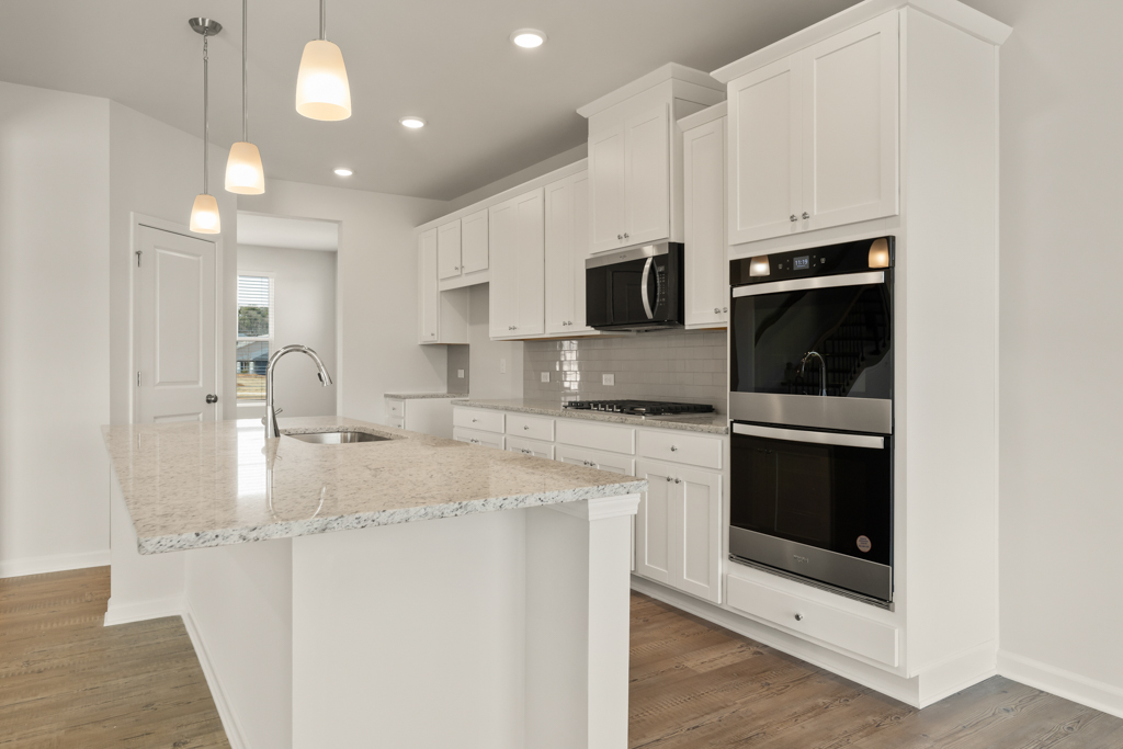 A kitchen with white cabinets.