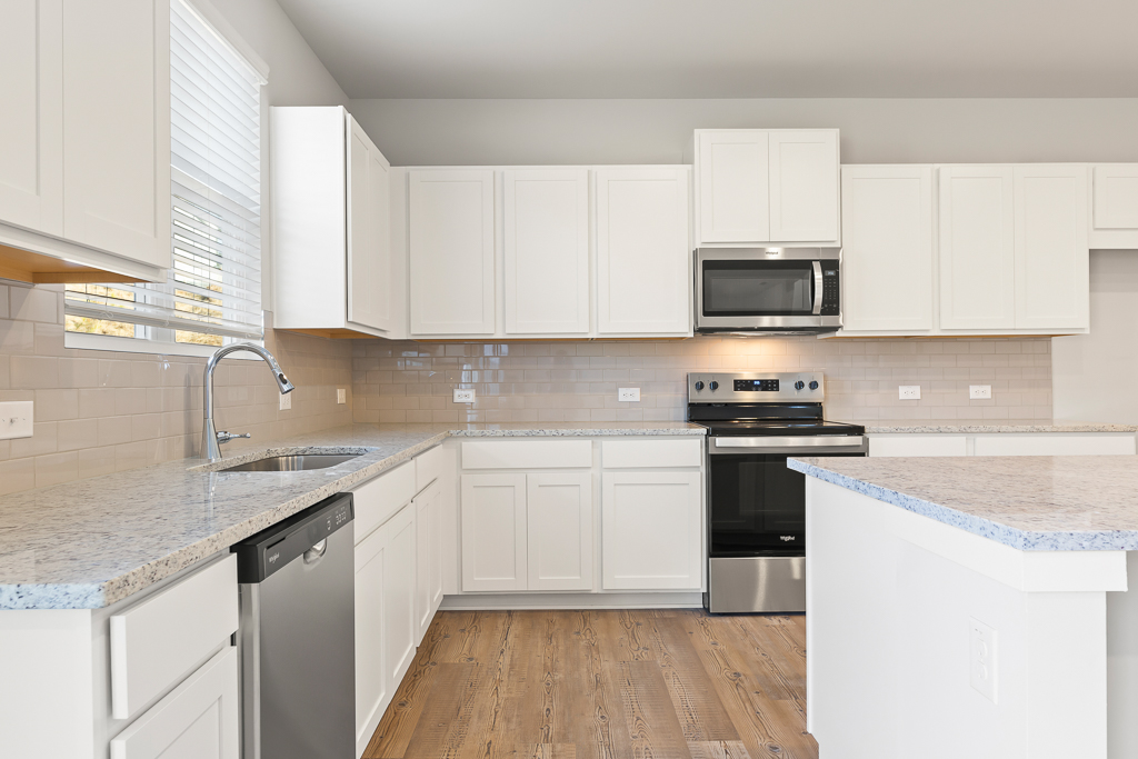 A kitchen with white cabinets.