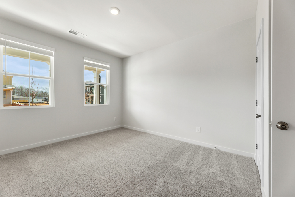 A room with a carpet and windows.
