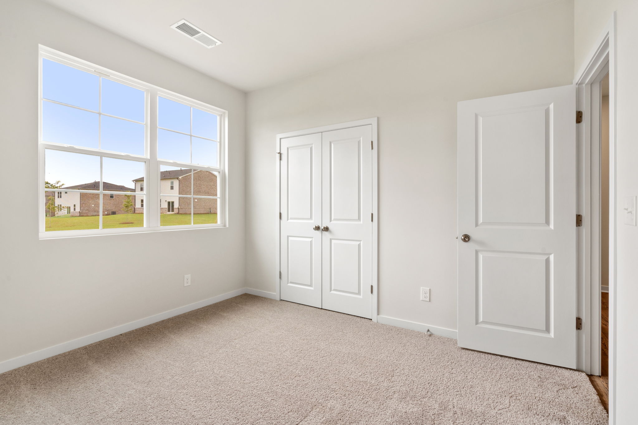 A room with white doors and a window.