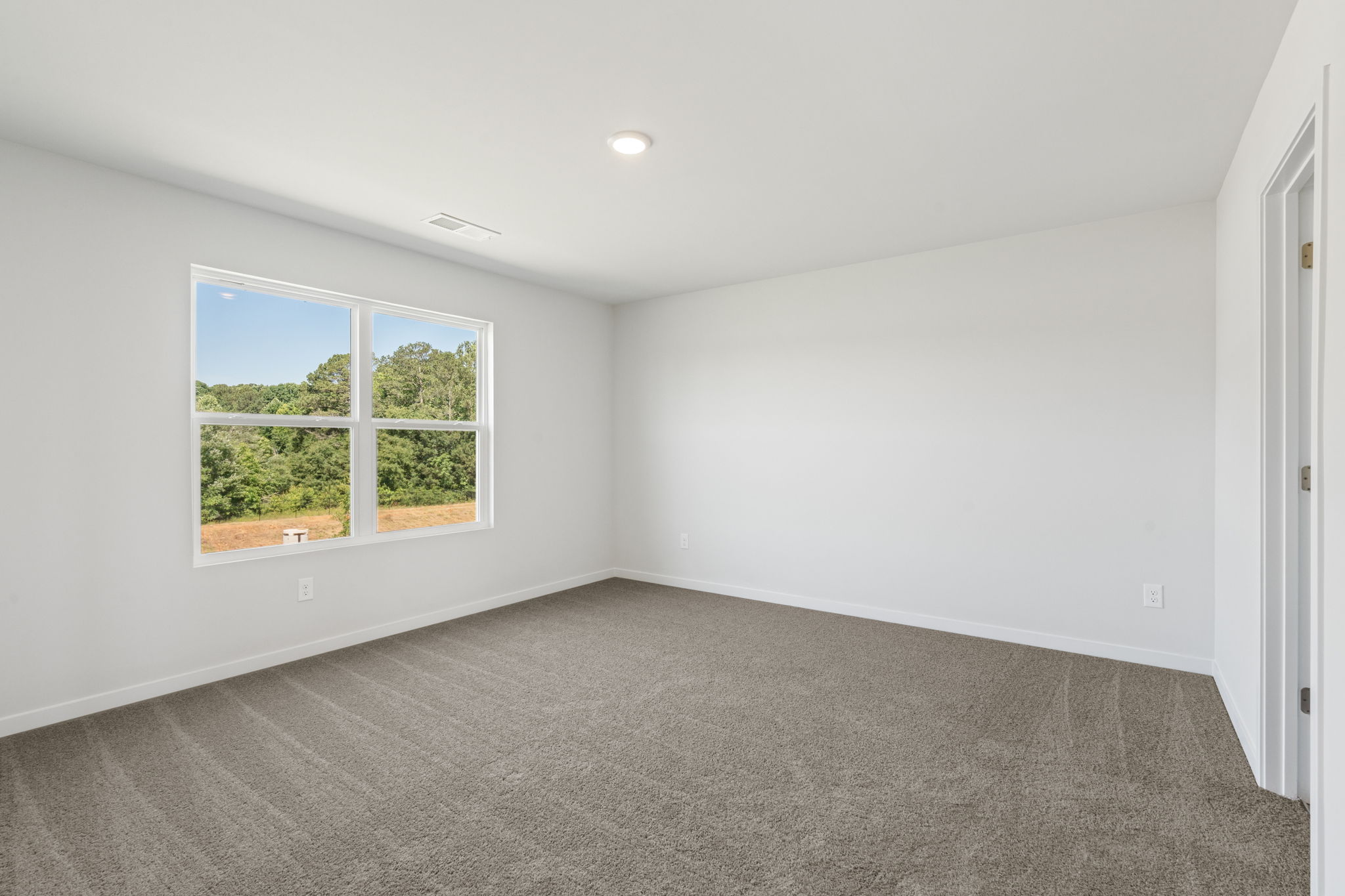 A room with a window and a carpet.
