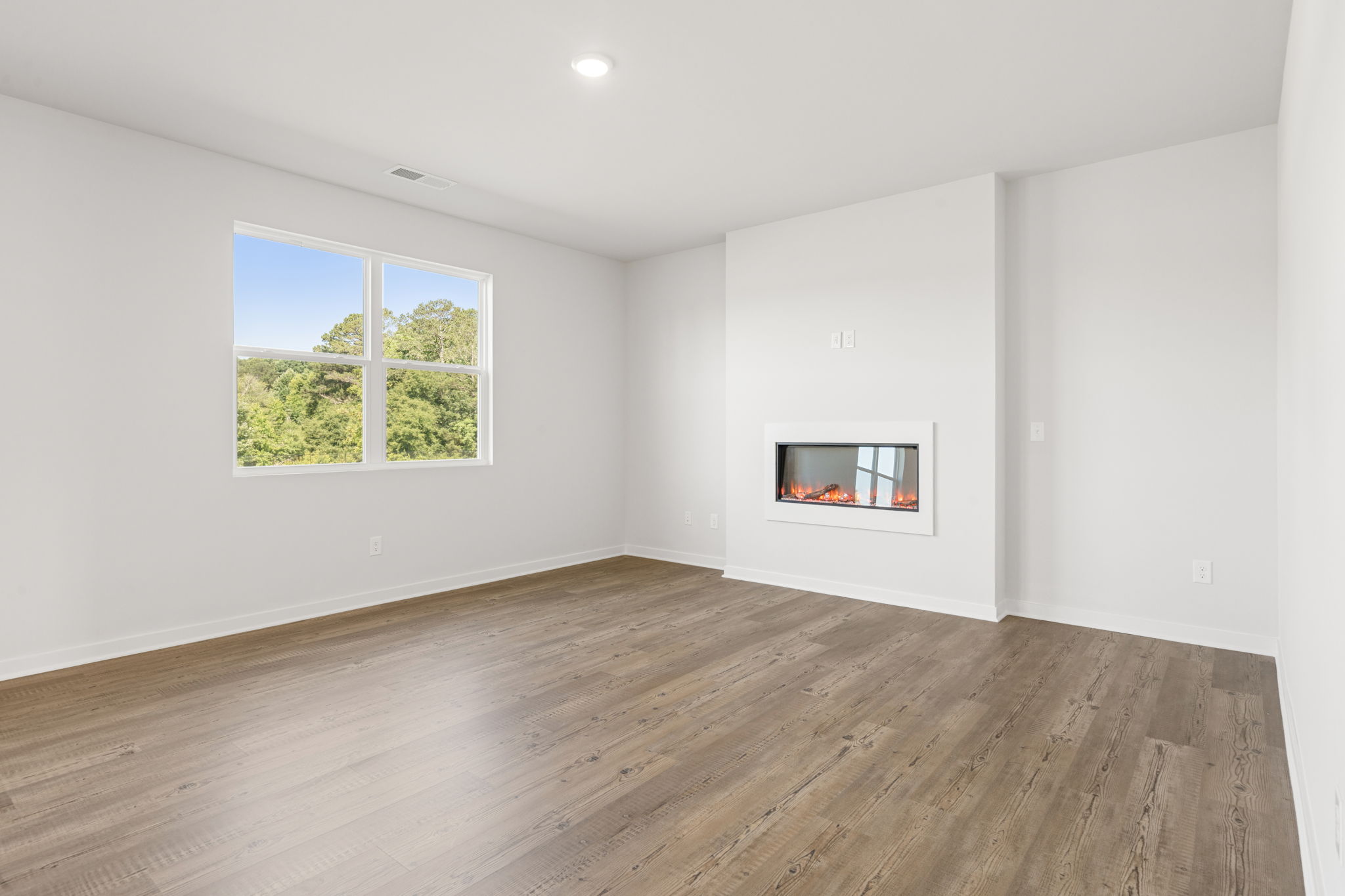 A room with a wood floor and a window with a painting on it.