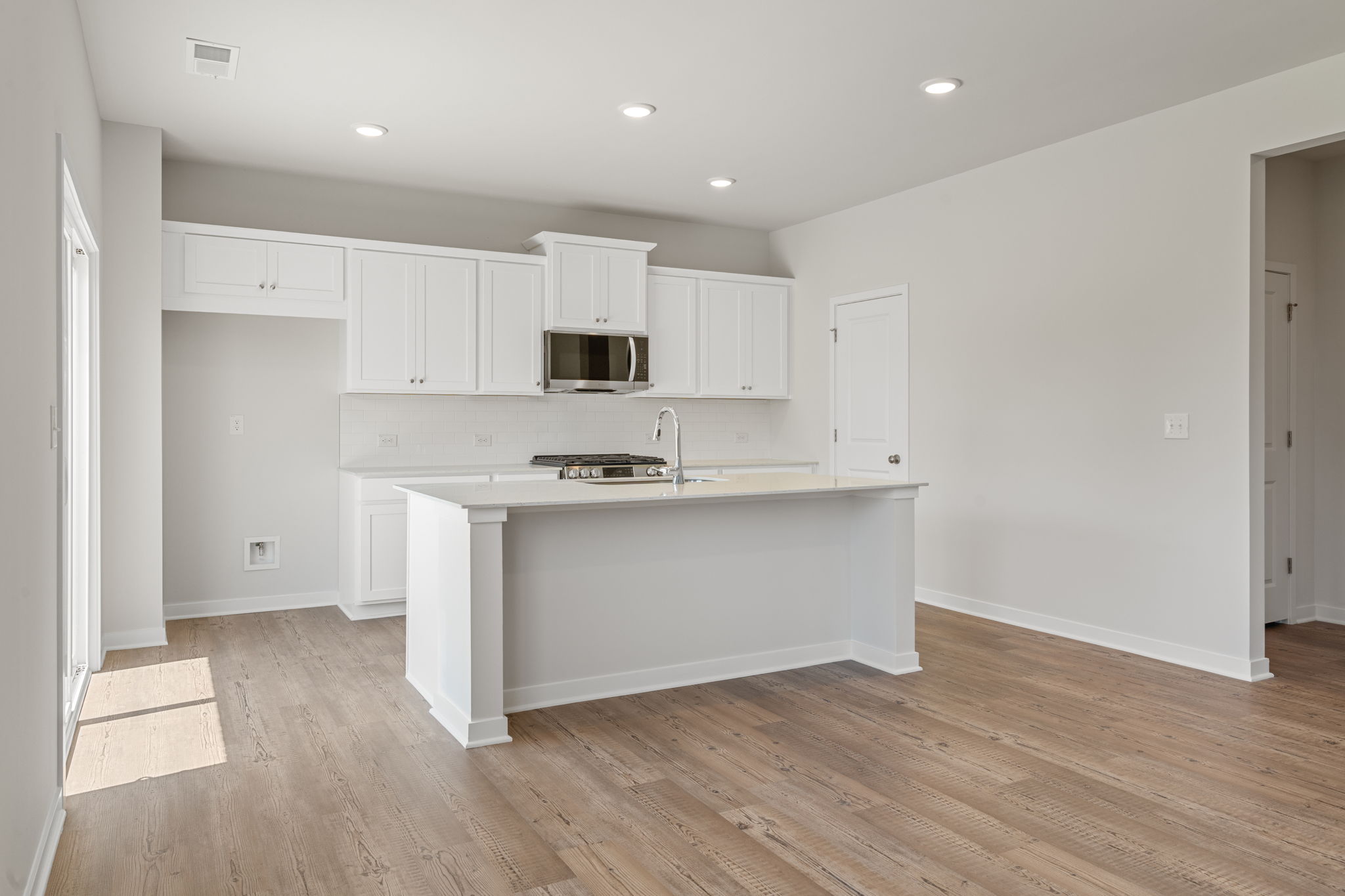 A kitchen with white cabinets.