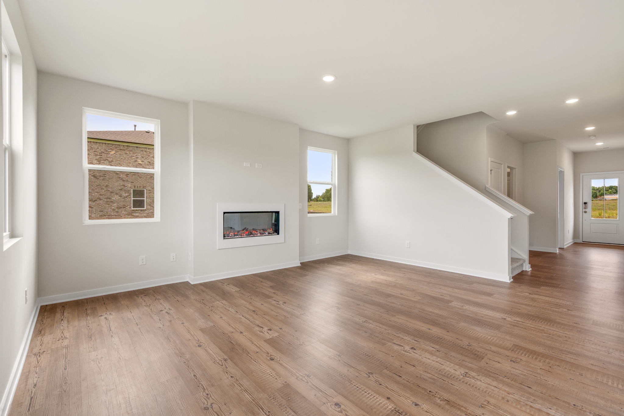A large empty room with a wood floor and white walls.