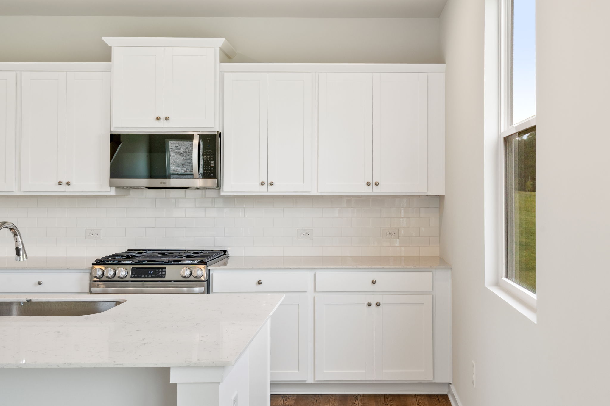 A kitchen with white cabinets.