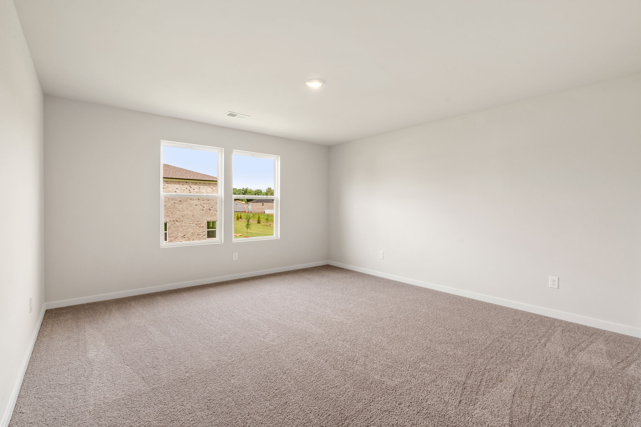 A room with a carpet and a window.