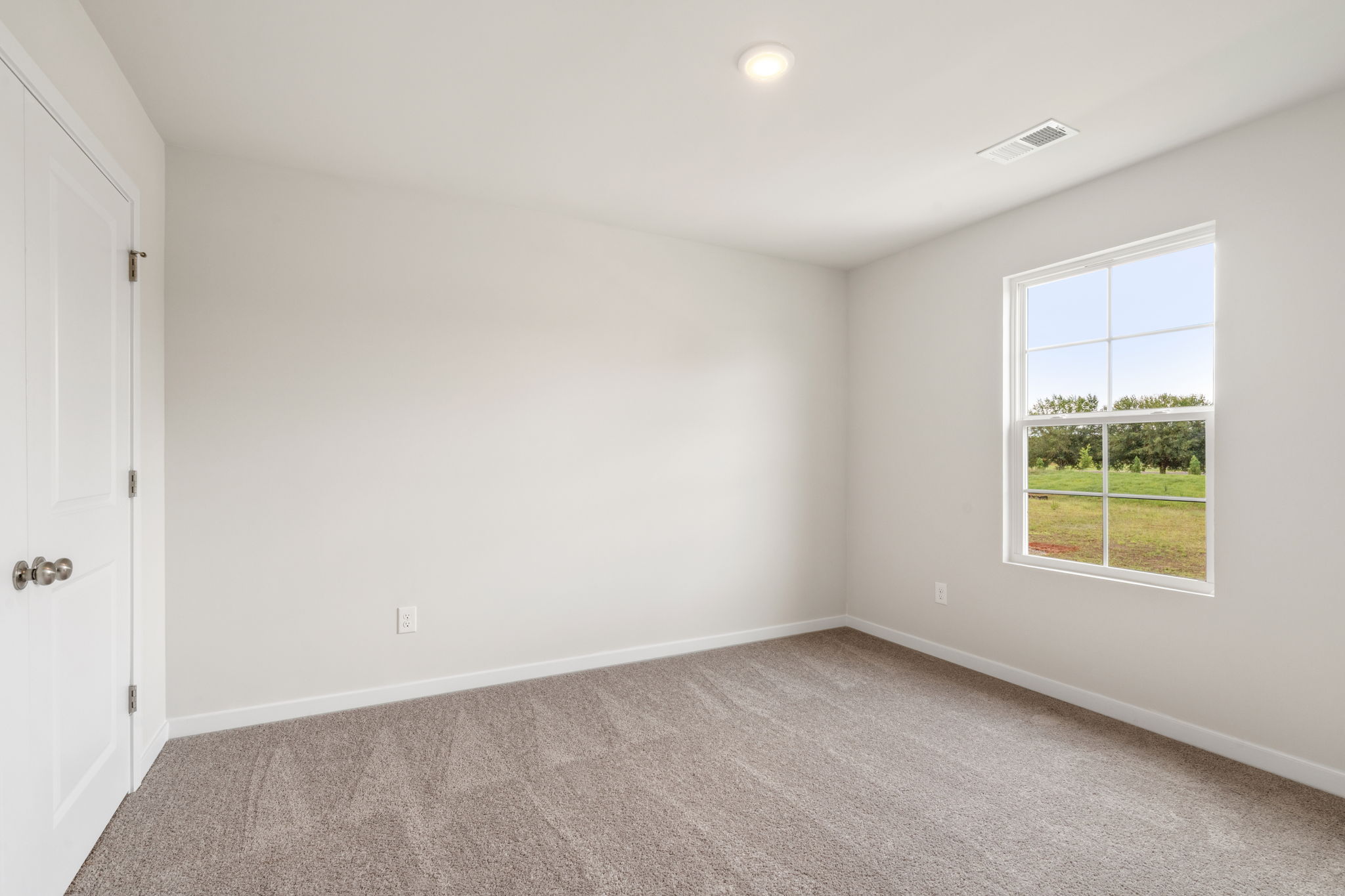 A room with a carpet and a window.