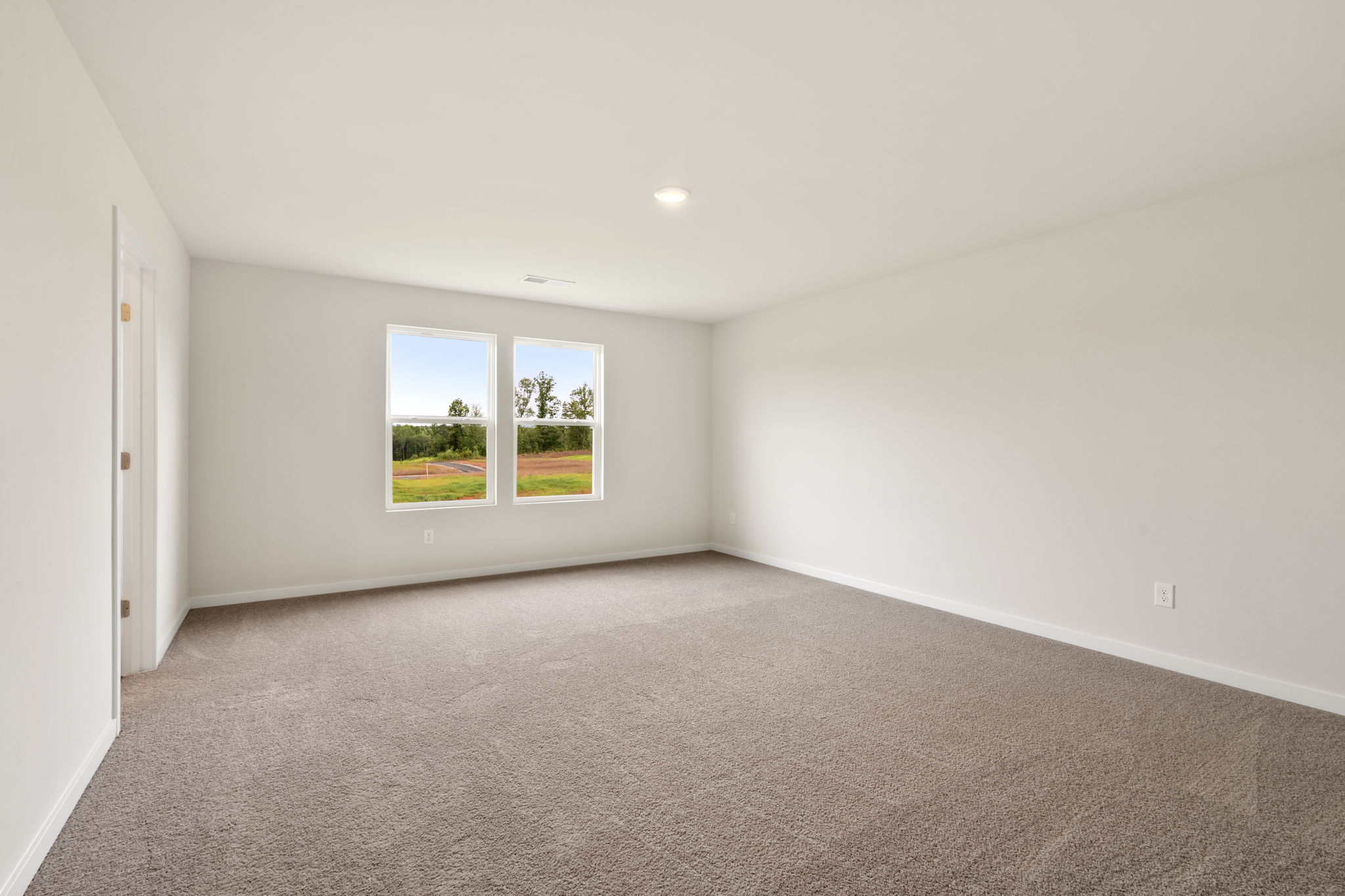A room with a window and a carpet.