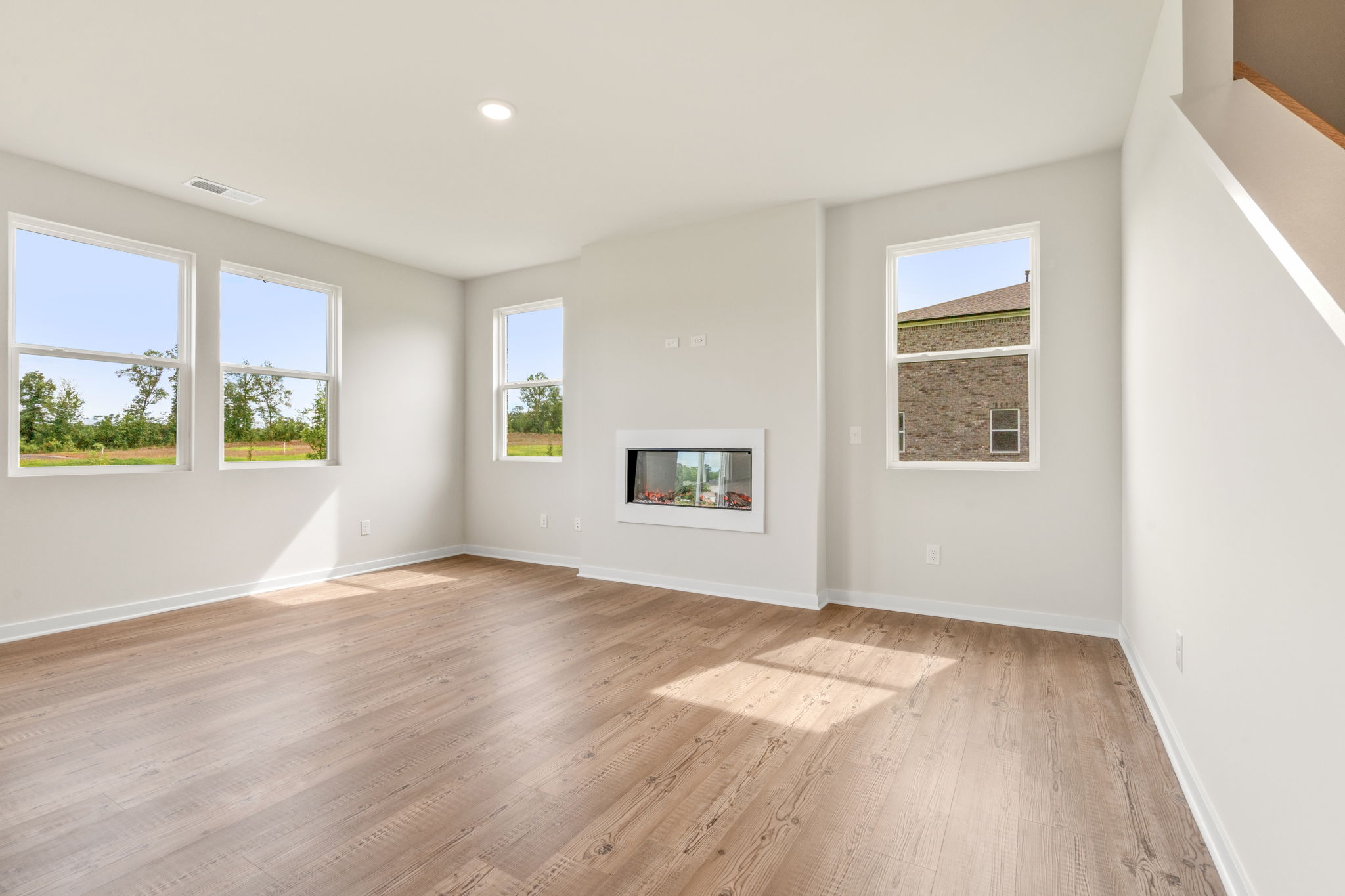 A room with a wood floor and windows.