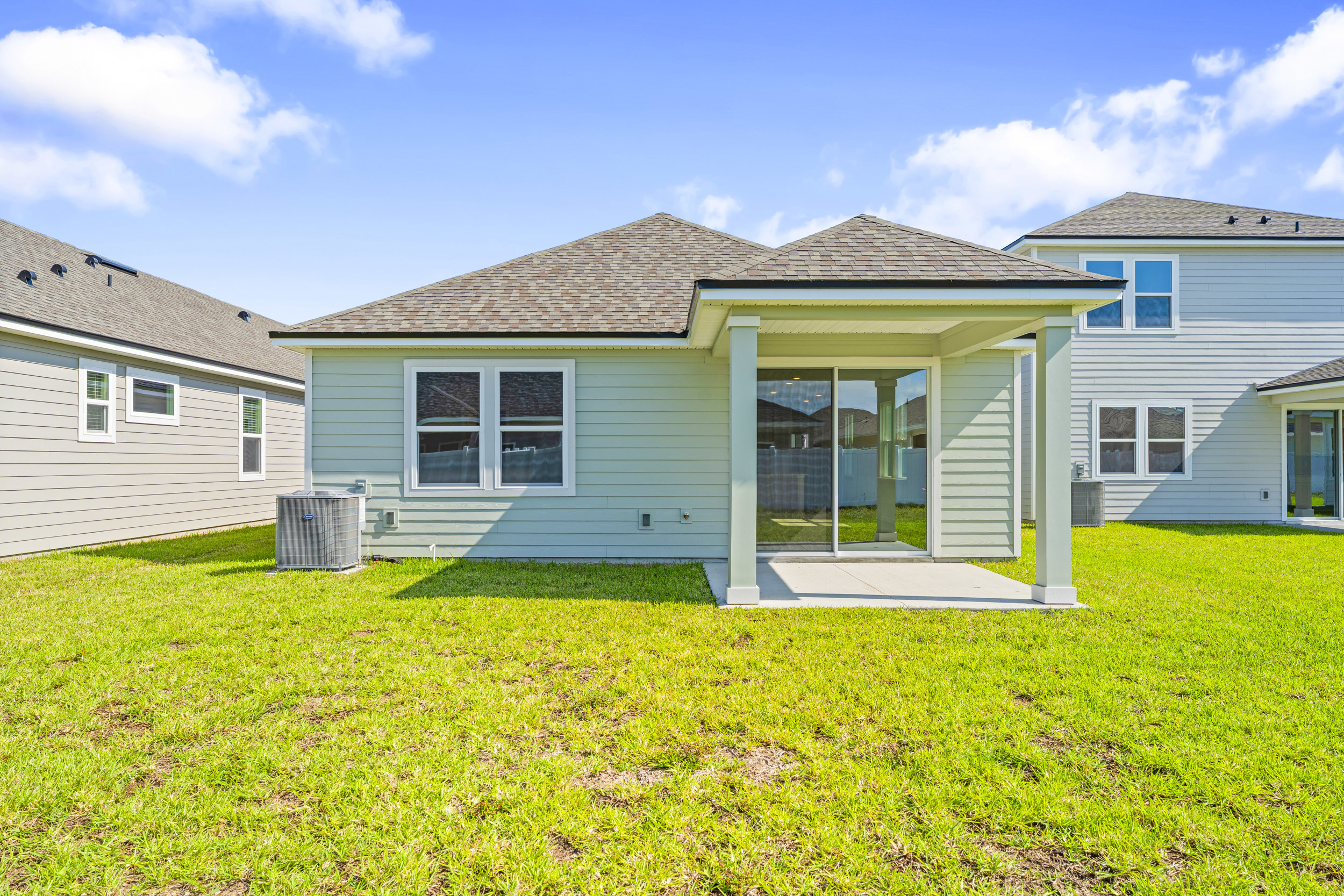 Lot 19 Cedar II Back Exterior of home with covered patio at Camden Woods in Kingsland, GA