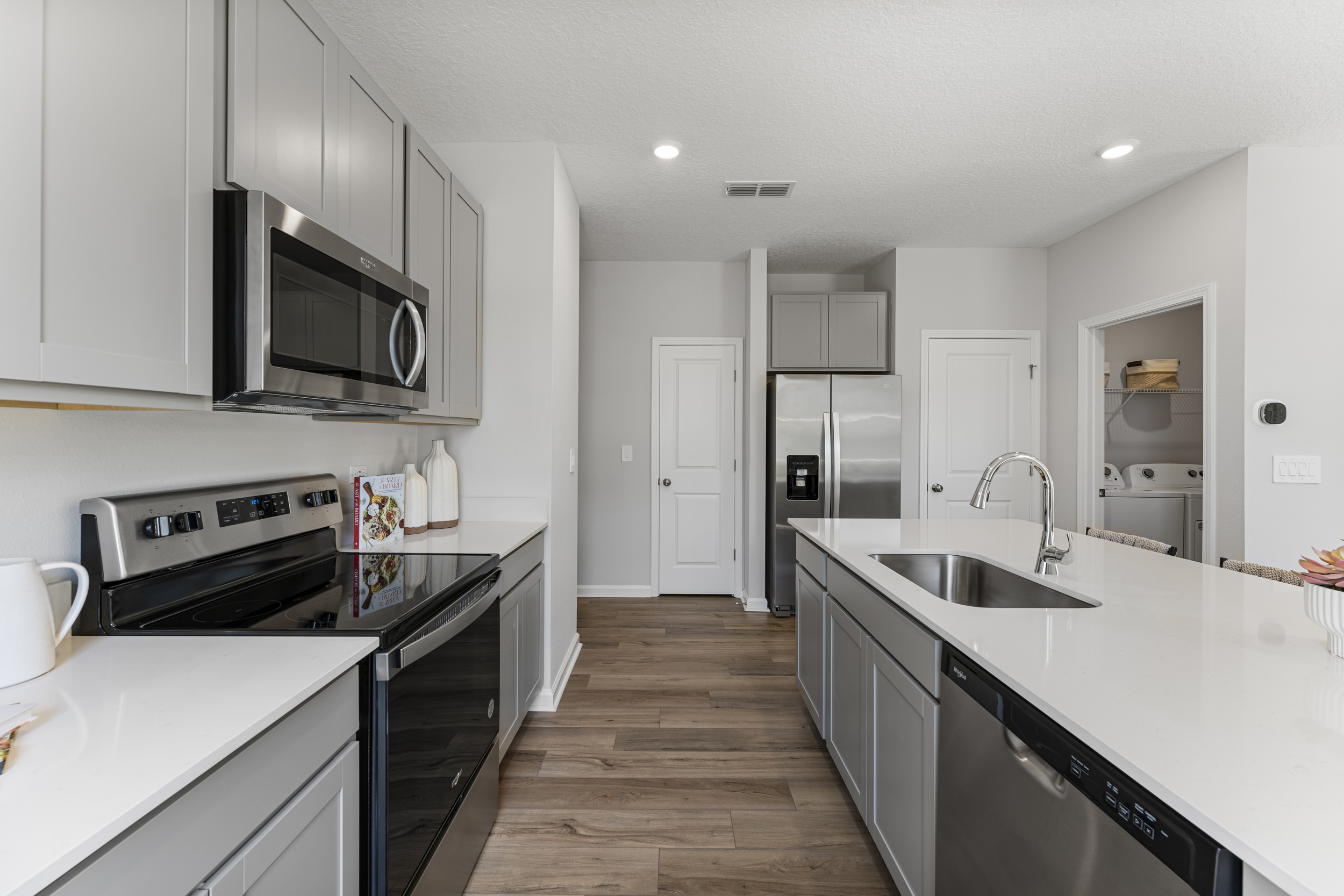 Sanibel Model Home Kitchen with White Quartz Counters at The Landings at Pecan Park in Jacksonville