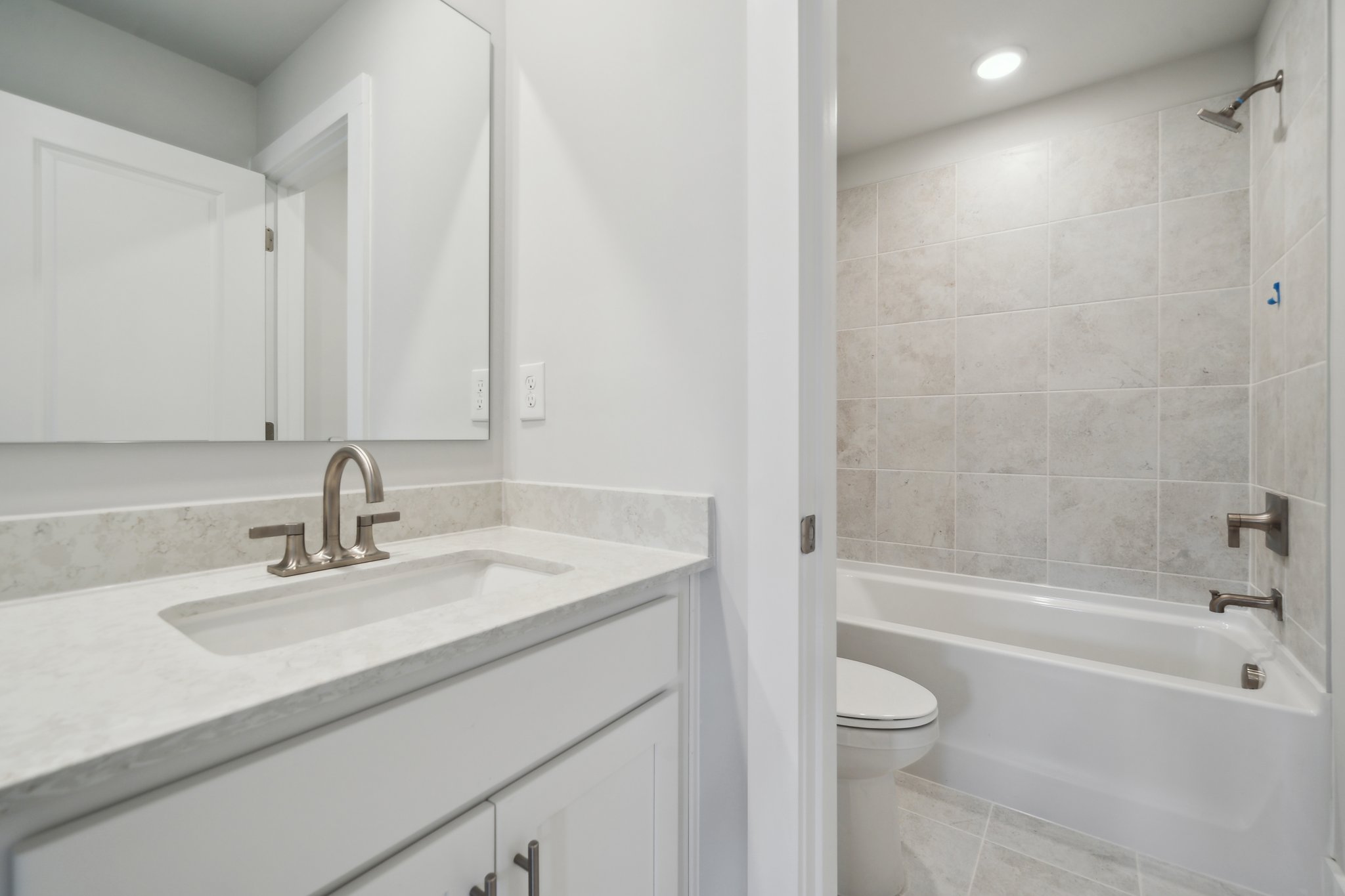 A bathroom with a tub sink and toilet.