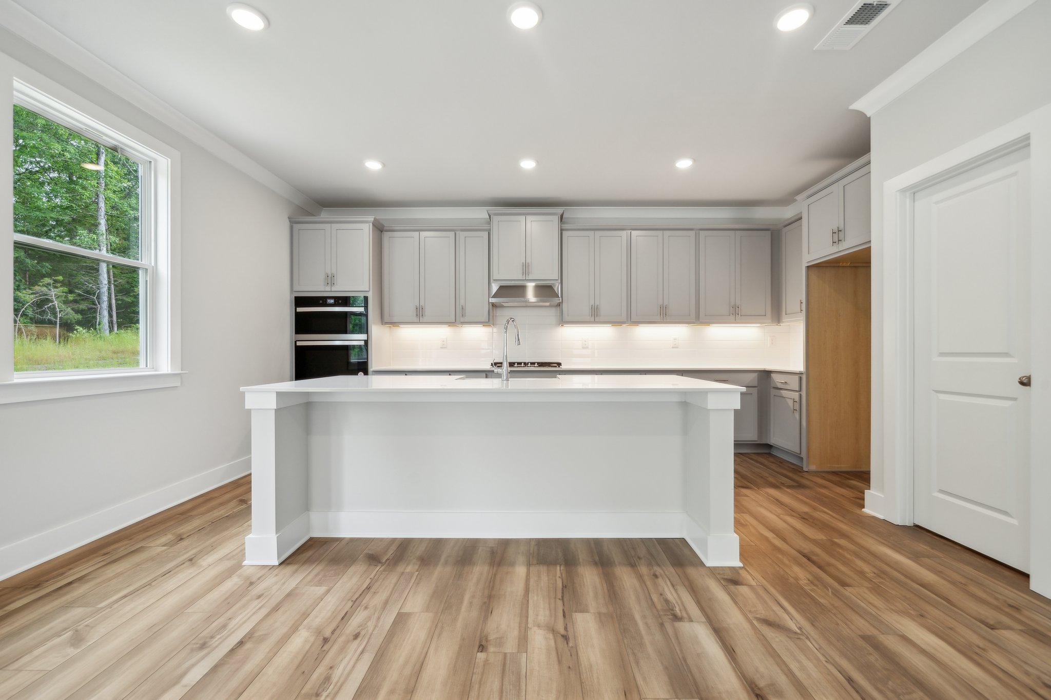 A kitchen with white cabinets.