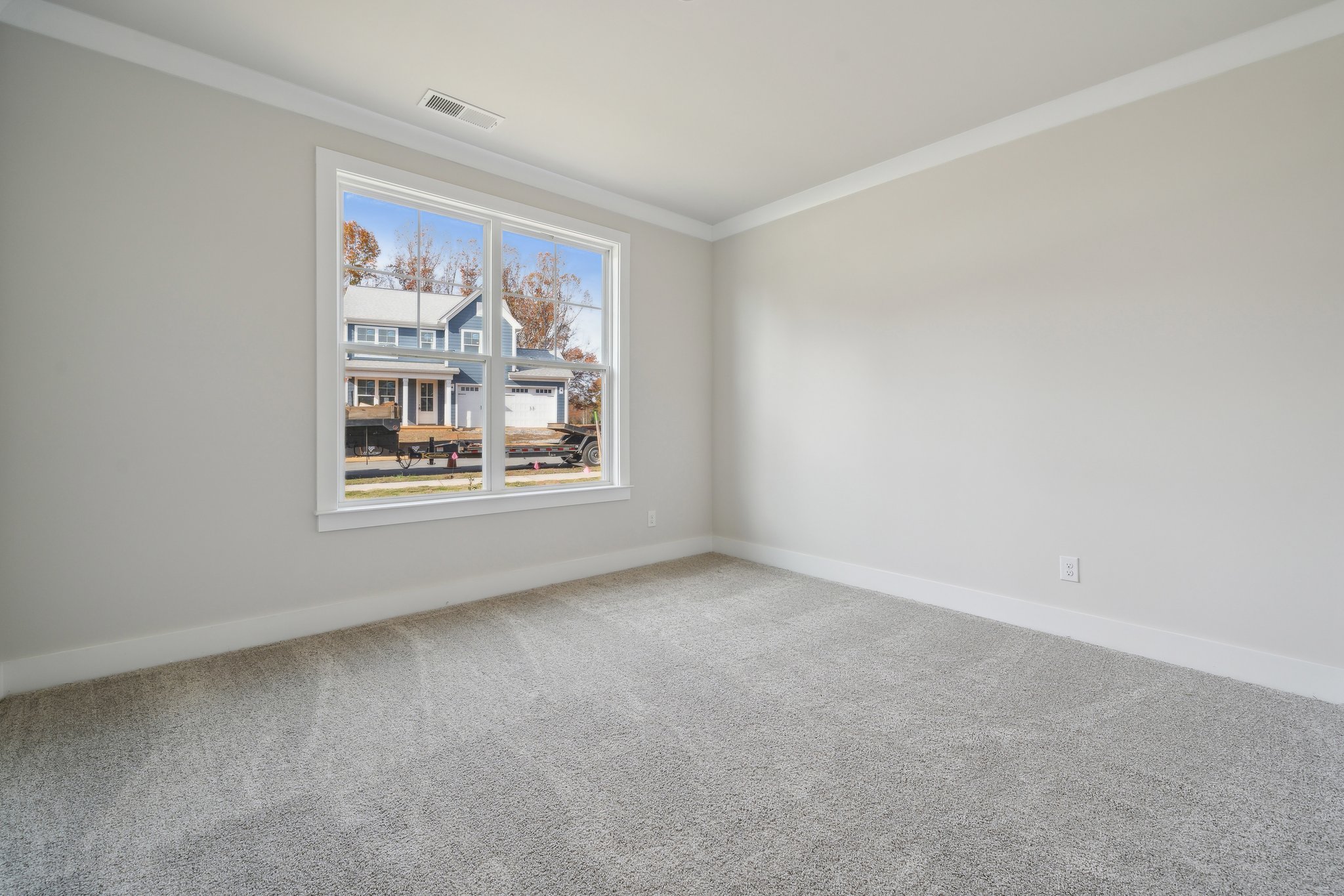 A room with a window and a carpet.