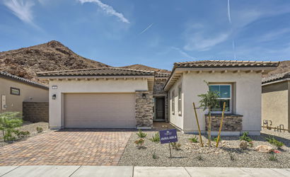 A building with a garage and a hill in the background.