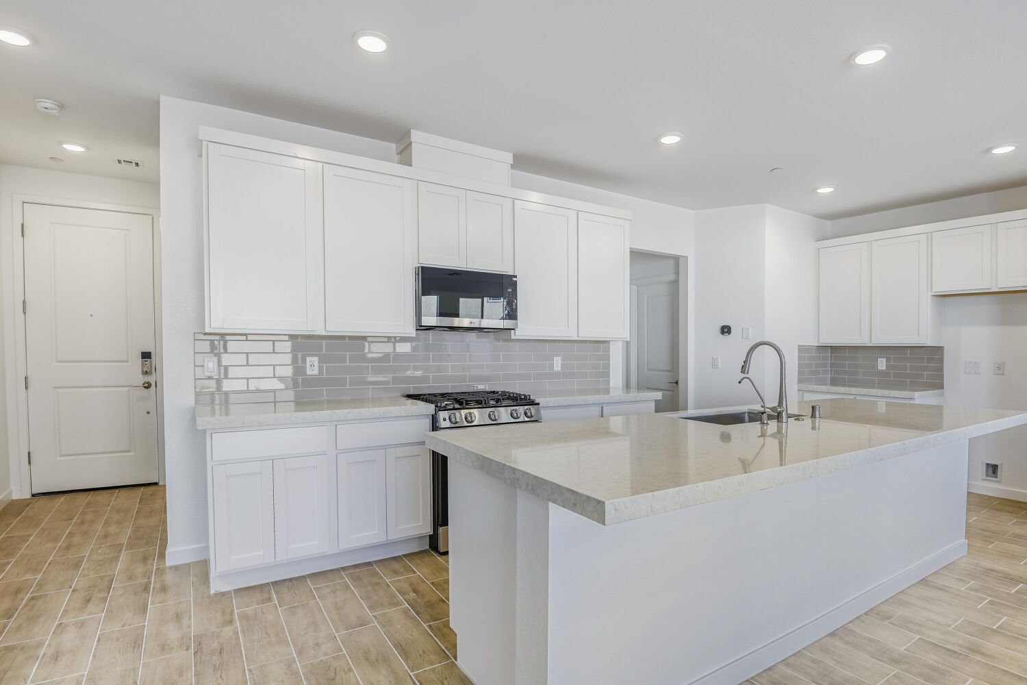 A kitchen with white cabinets.