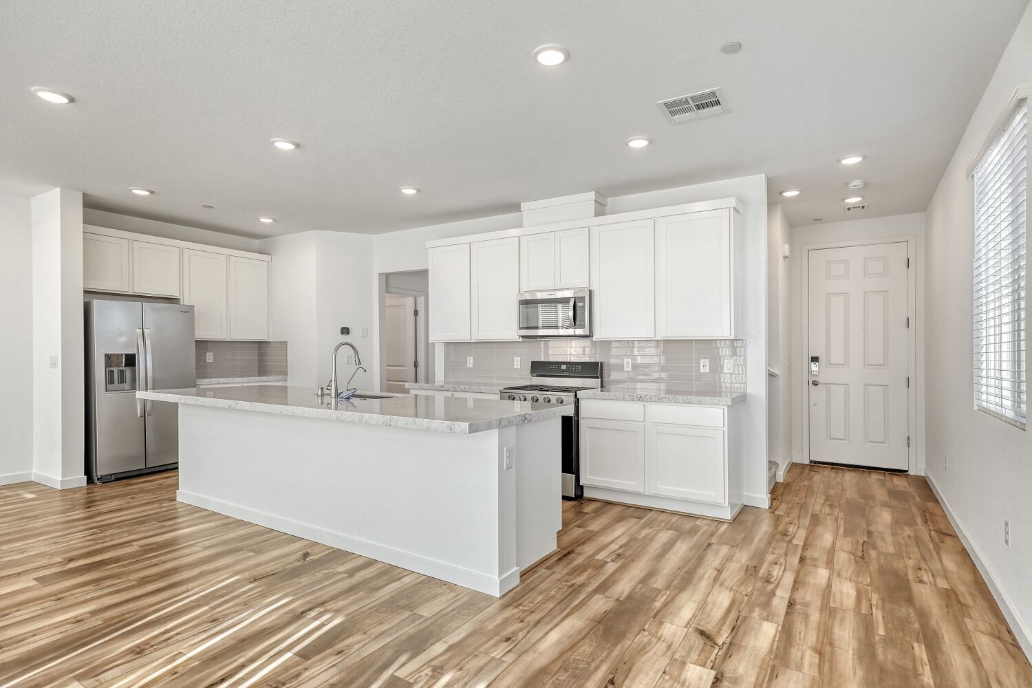 A kitchen with white cabinets.