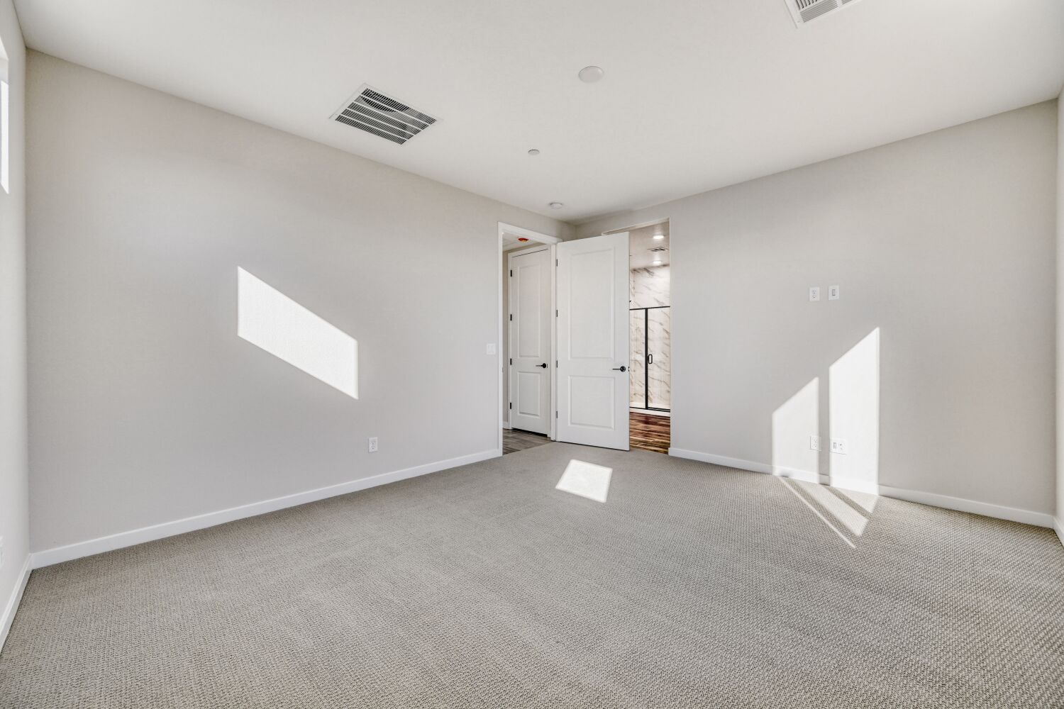 A long hallway with white doors.