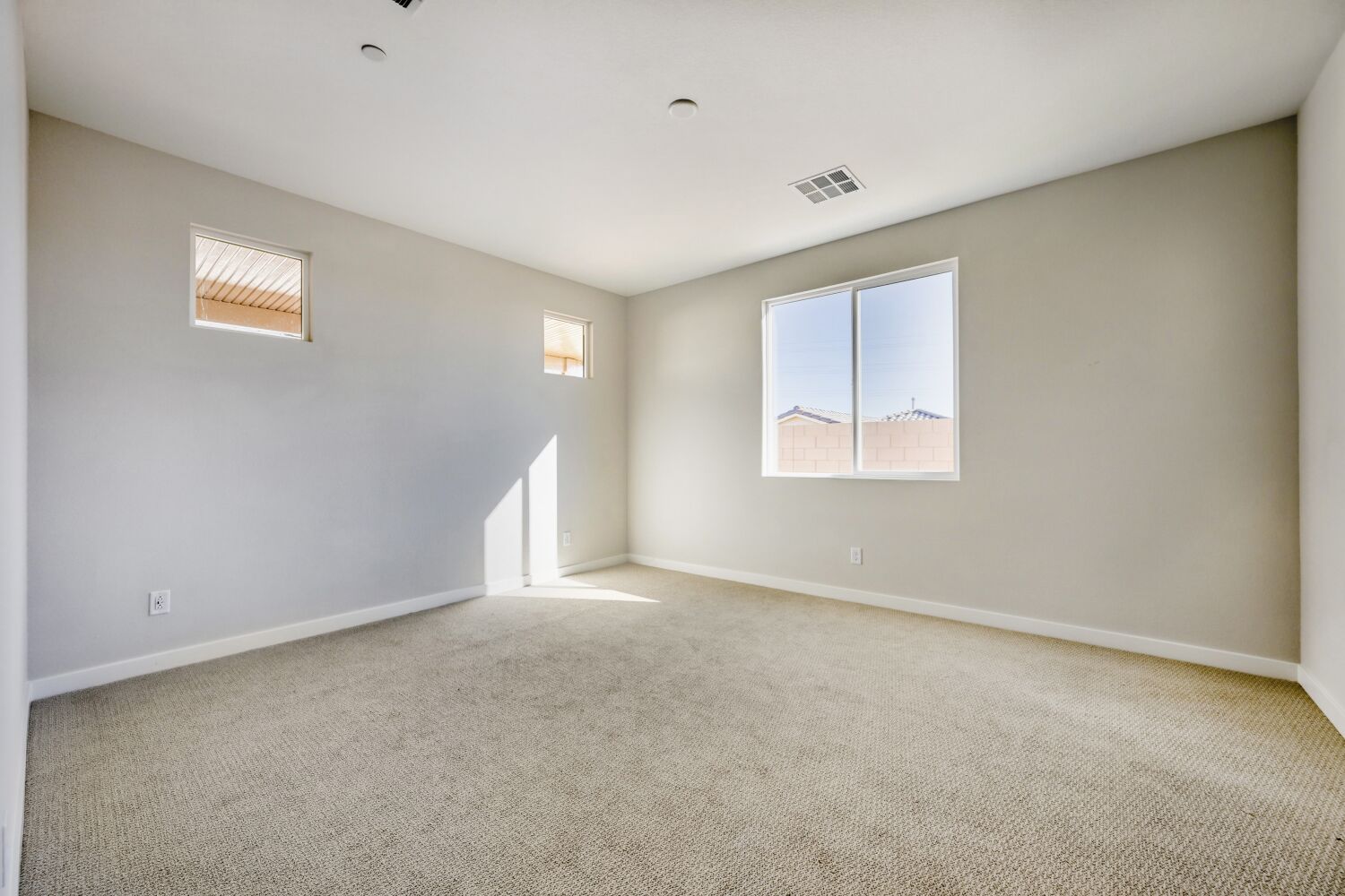 A room with a carpet and a window.